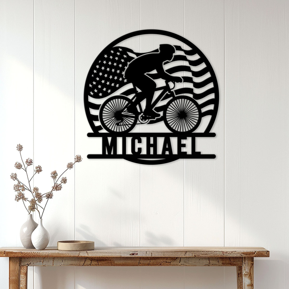 Cyclist wall decor displayed above a console table, featuring a rider silhouette and American flag