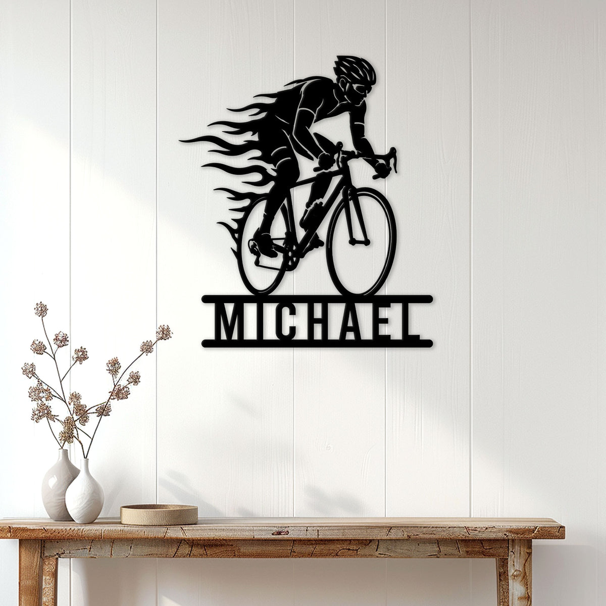 Racing cyclist metal wall sign displayed above a console table in a bright modern home