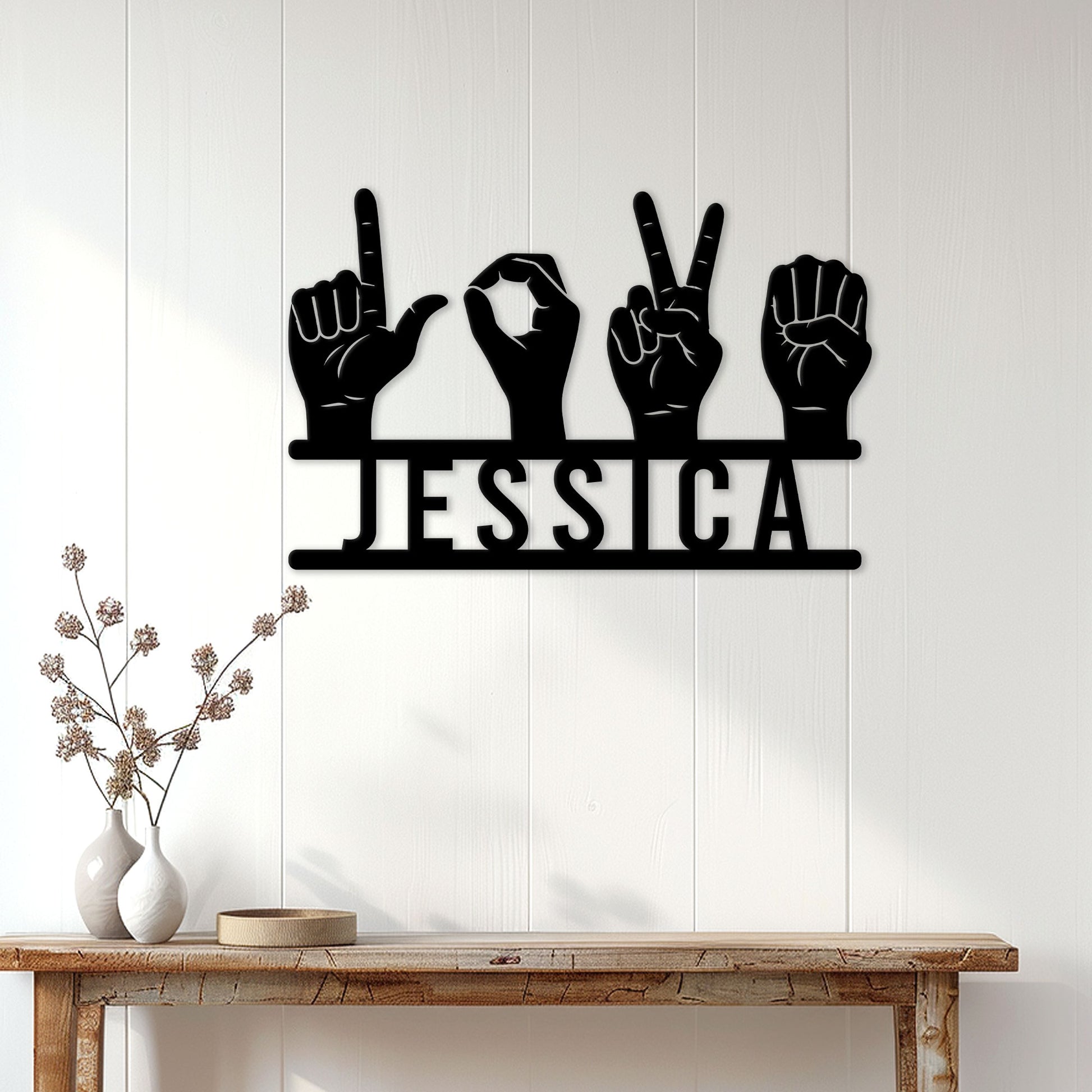 Sign language wall decor displayed on a light wood-paneled wall above a console table