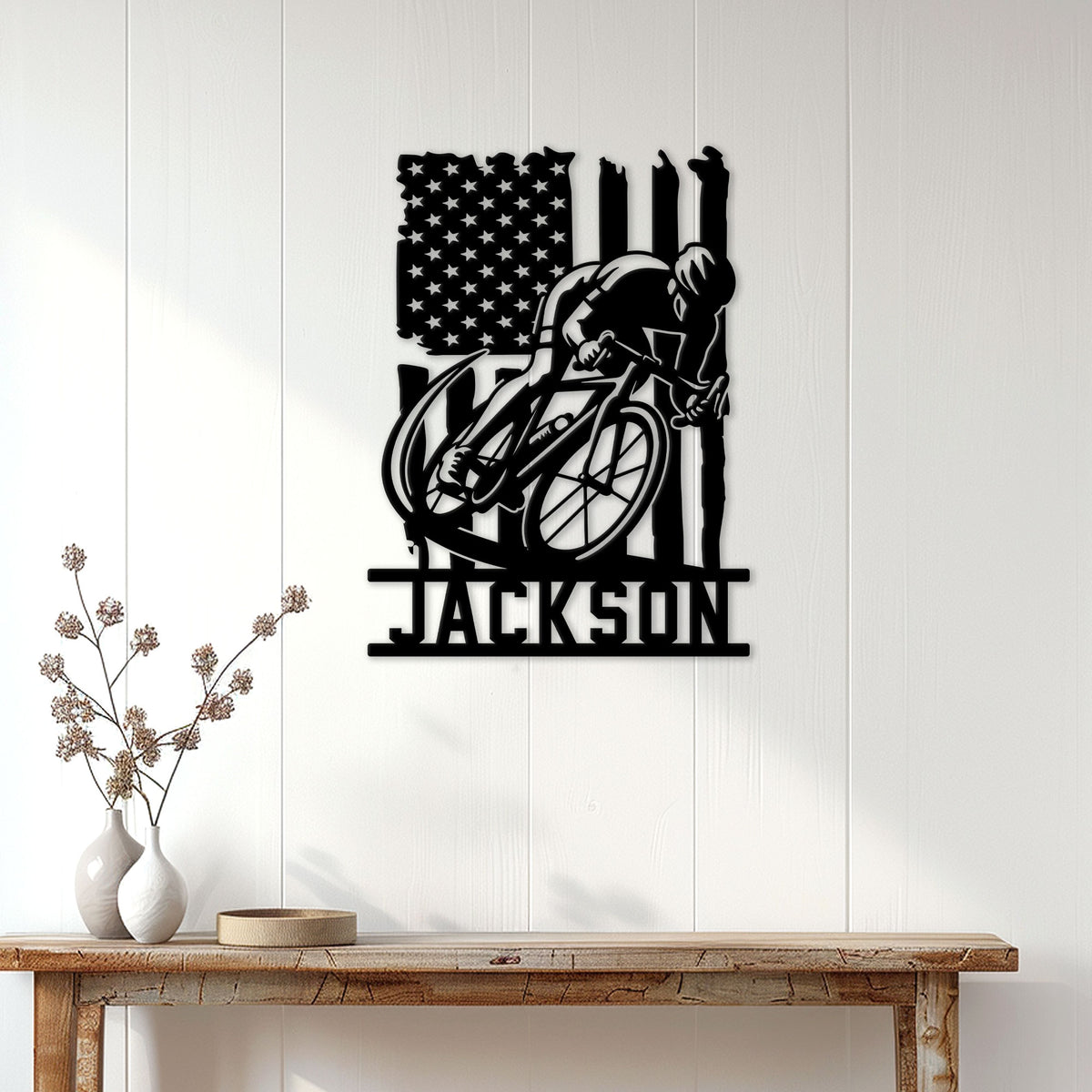 Patriotic cyclist wall sign displayed on a white paneled wall above a console table