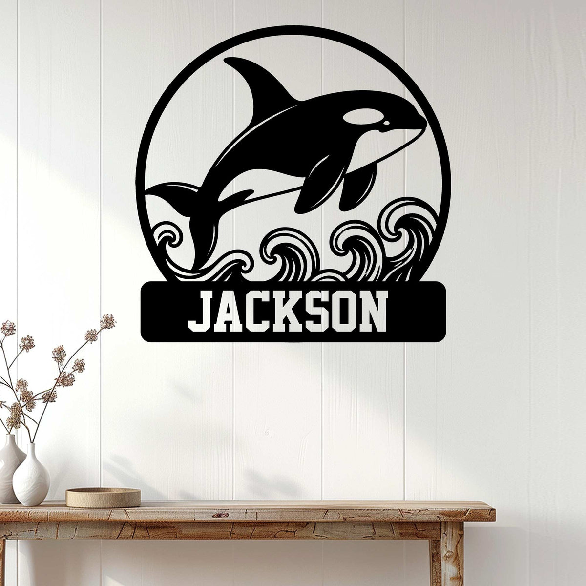 Orca wall decor displayed on a light wood-paneled wall above a console table