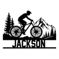 Mountain biking metal sign featuring a rider silhouette, mountain peaks, pine trees, and a custom design
