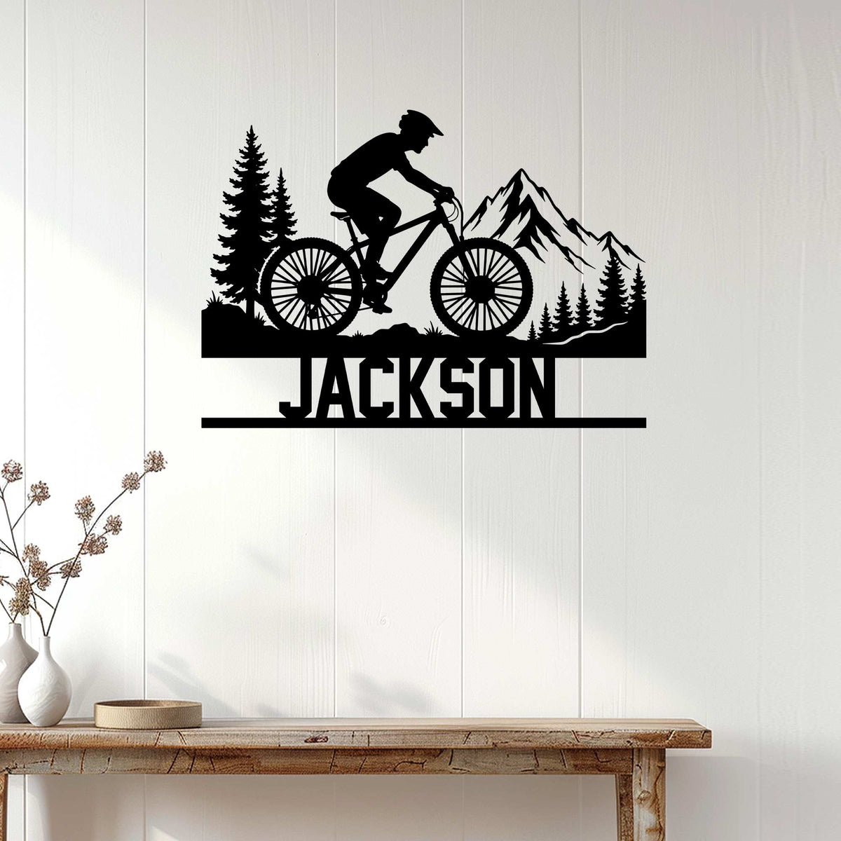 Mountain biking metal wall decor displayed on white wood paneling above a rustic console table