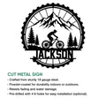 Mountain biking cut metal sign featuring a mountain trail cyclist, forest silhouette, and rugged tire-shaped frame