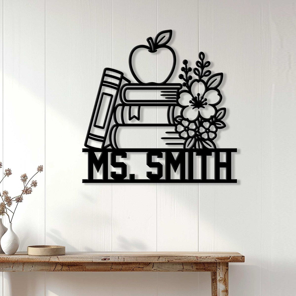 Teacher wall decor displayed above a console table, featuring books, an apple, pencil, and floral accents