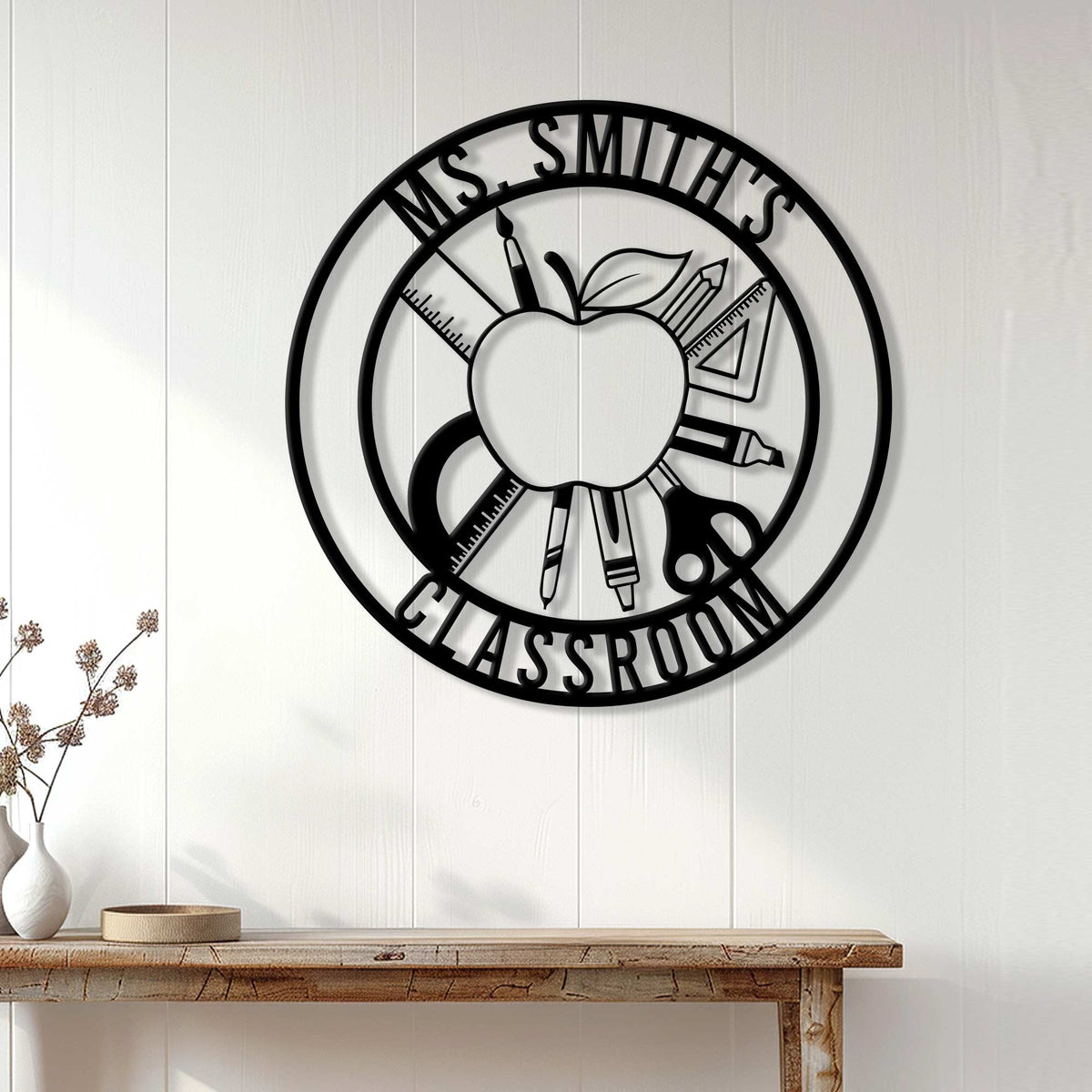 Black teacher metal wall sign displayed on a white paneled wall above a console table