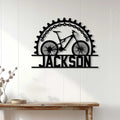 Cyclist metal wall sign displayed on a light wood-paneled wall above a console table
