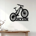 Mountain bike silhouette sign displayed as cyclist wall decor above a wood console in a bright room