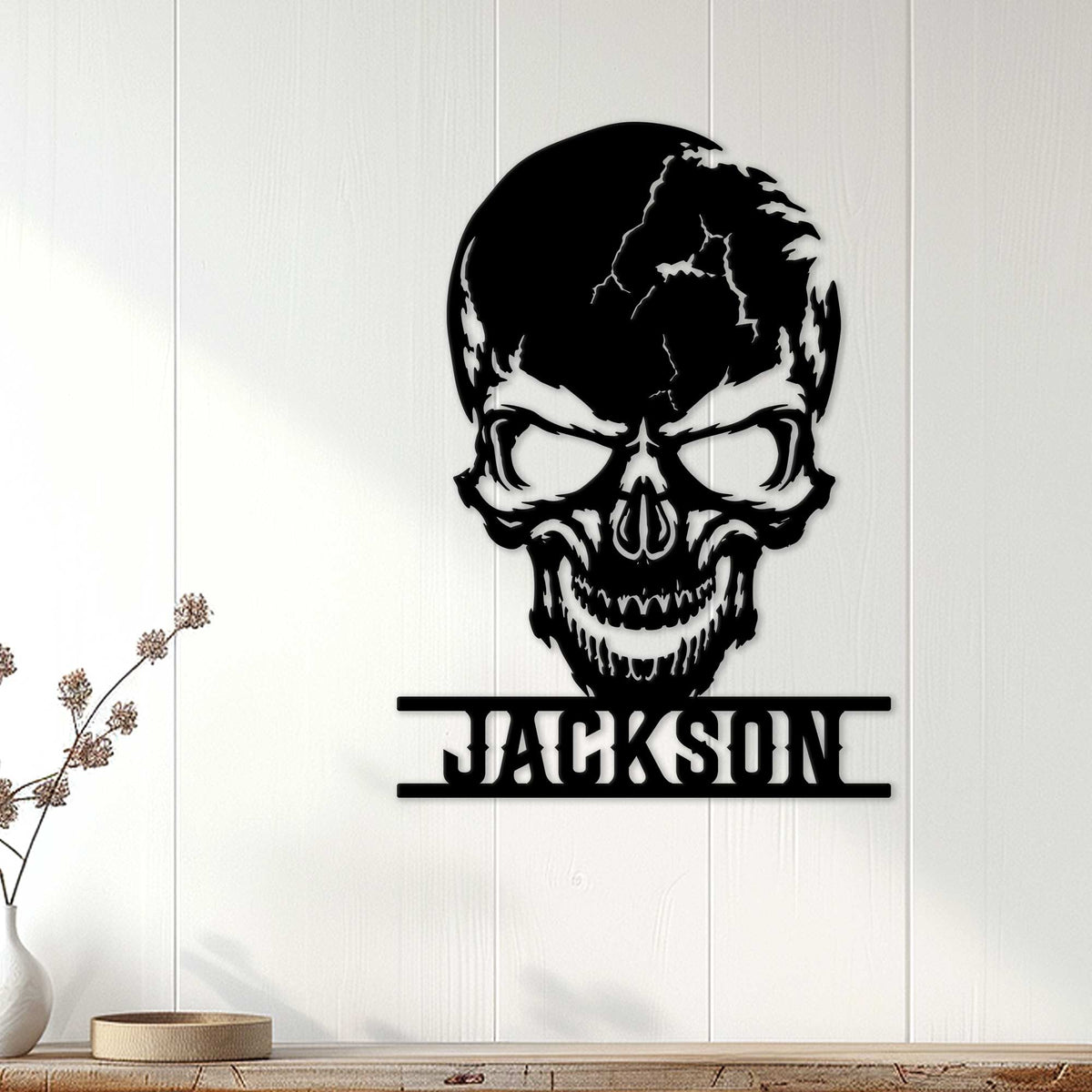 Black skull metal wall sign styled on a light paneled wall in a modern home setting