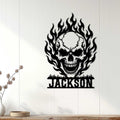 Flaming skull metal sign displayed as bold wall decor on a light wood-paneled wall