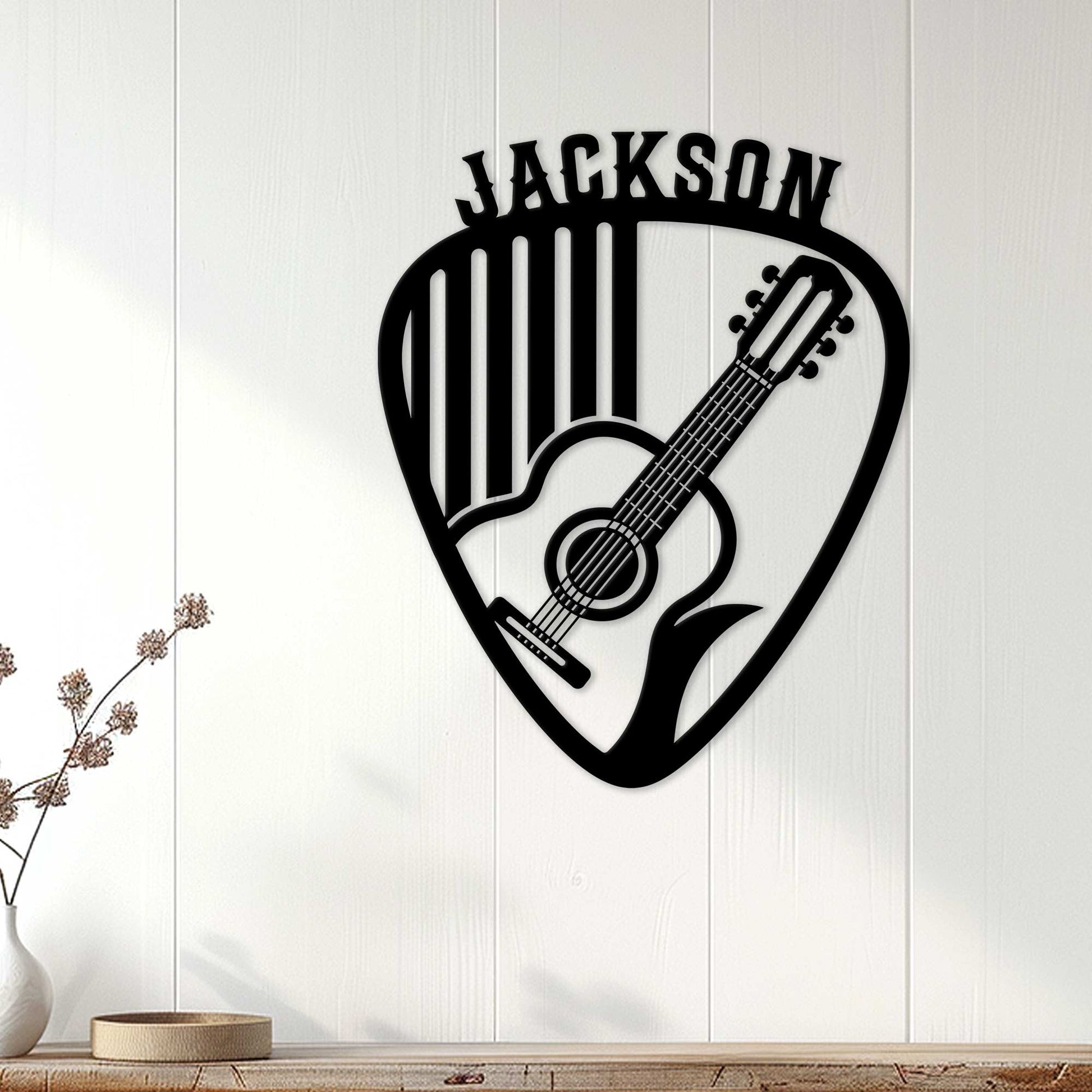Guitar pick wall sign with acoustic guitar silhouette displayed on a bright paneled wall