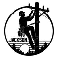Round lineman metal sign featuring a utility worker climbing a power pole with tools and overhead lines