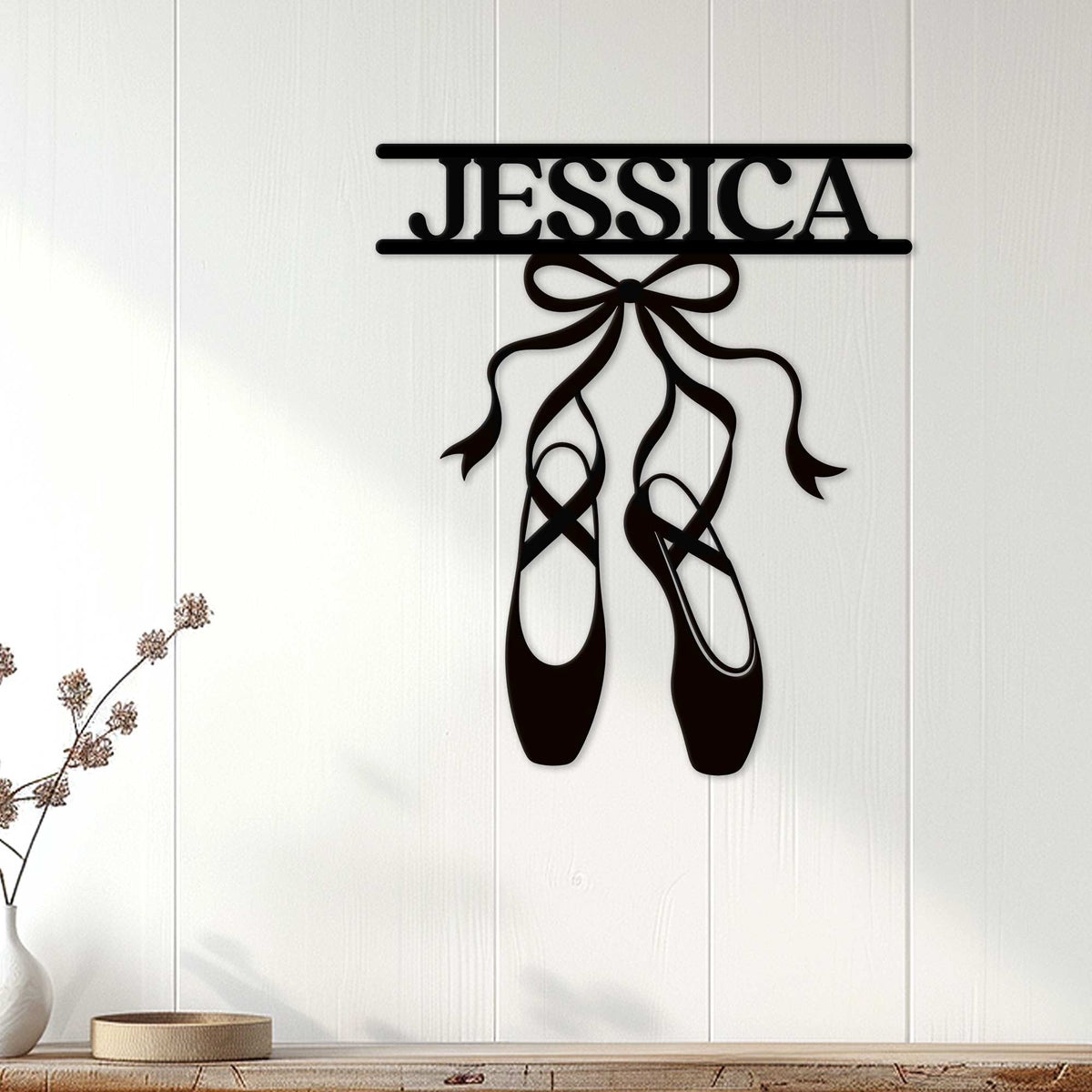 Black ballet shoe wall sign displayed on a light wood-paneled wall as bedroom decor