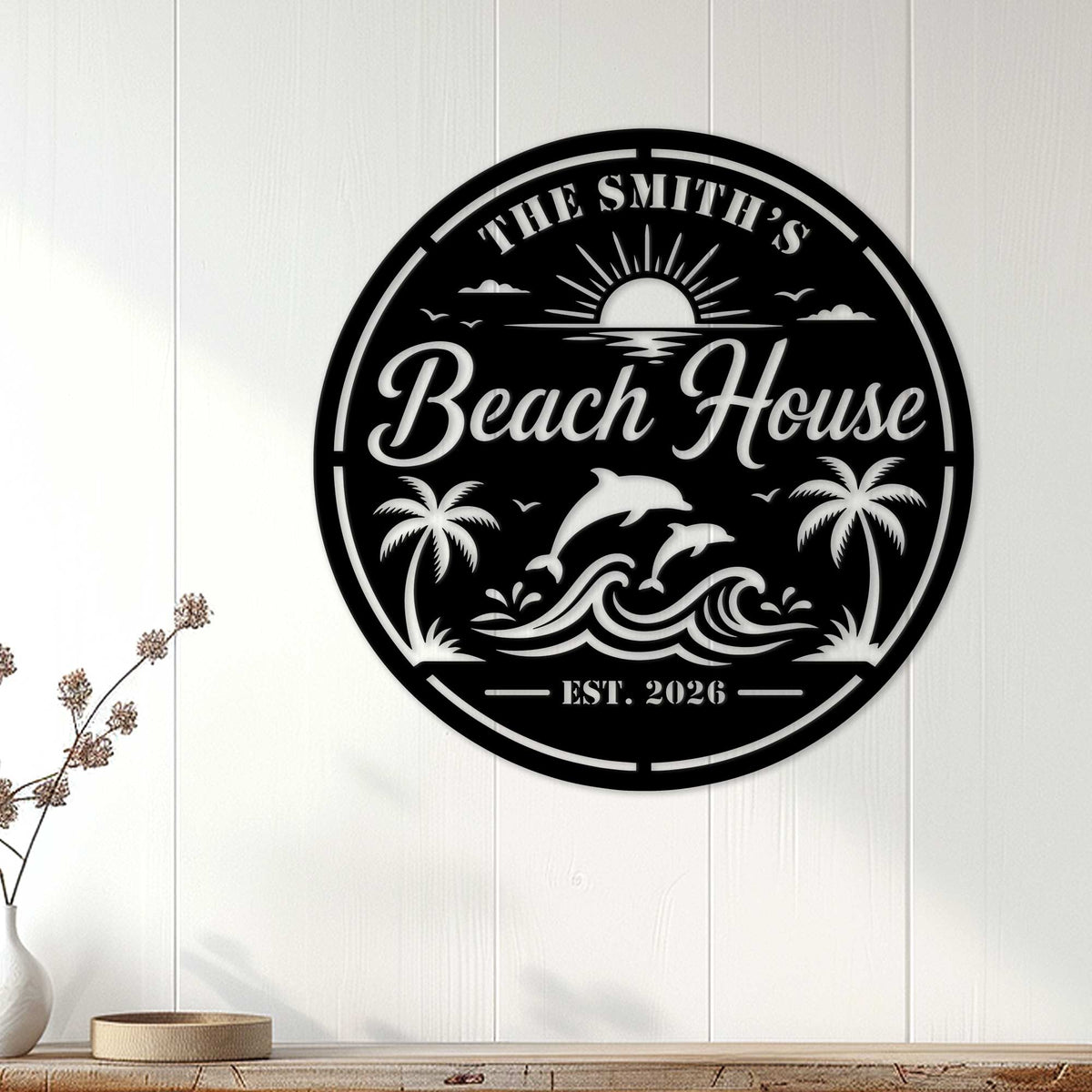 Round beach house wall sign displayed on white coastal paneling above a console table