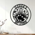 Artist wall decor displayed on a white paneled wall above a console in a bright room