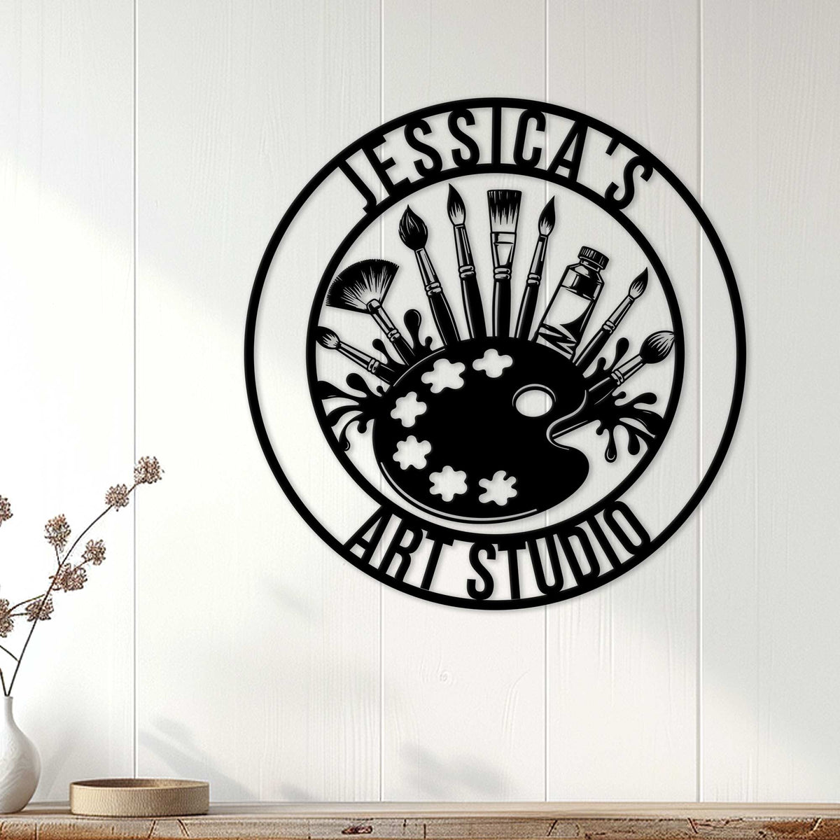 Artist wall decor displayed on a white paneled wall above a console in a bright room
