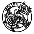 Tattoo artist metal sign featuring a hand with tattoo machine, rose, ink bottle, and bold circular design