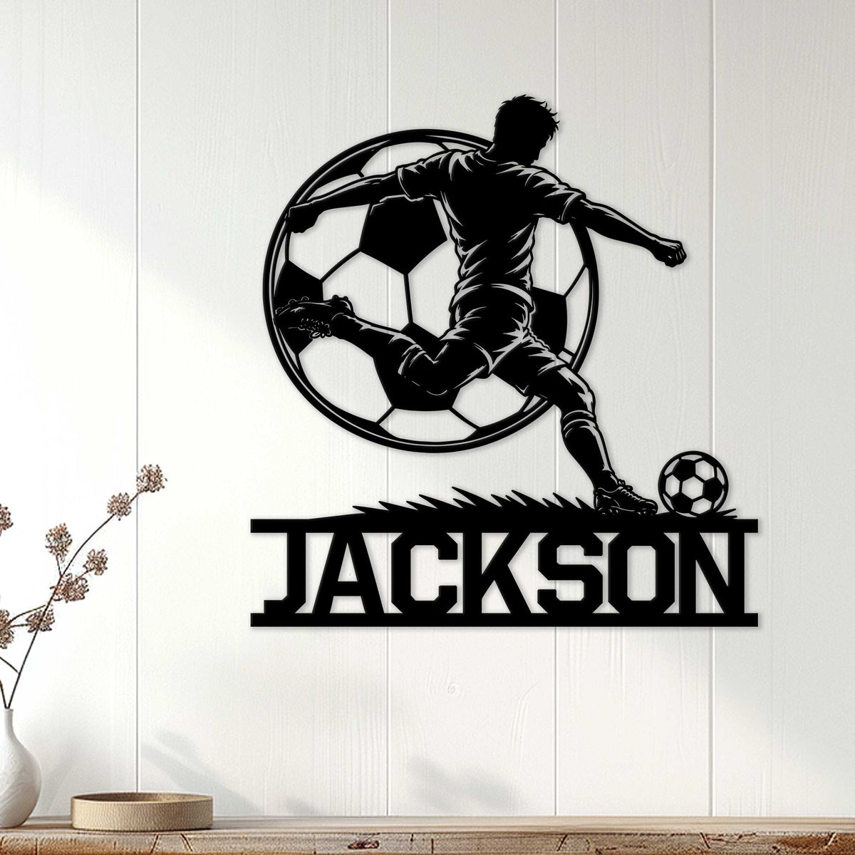 Black soccer player metal wall sign displayed on a light wood-paneled interior wall