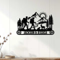 Black hiking couple silhouette sign displayed on a white wood-paneled wall
