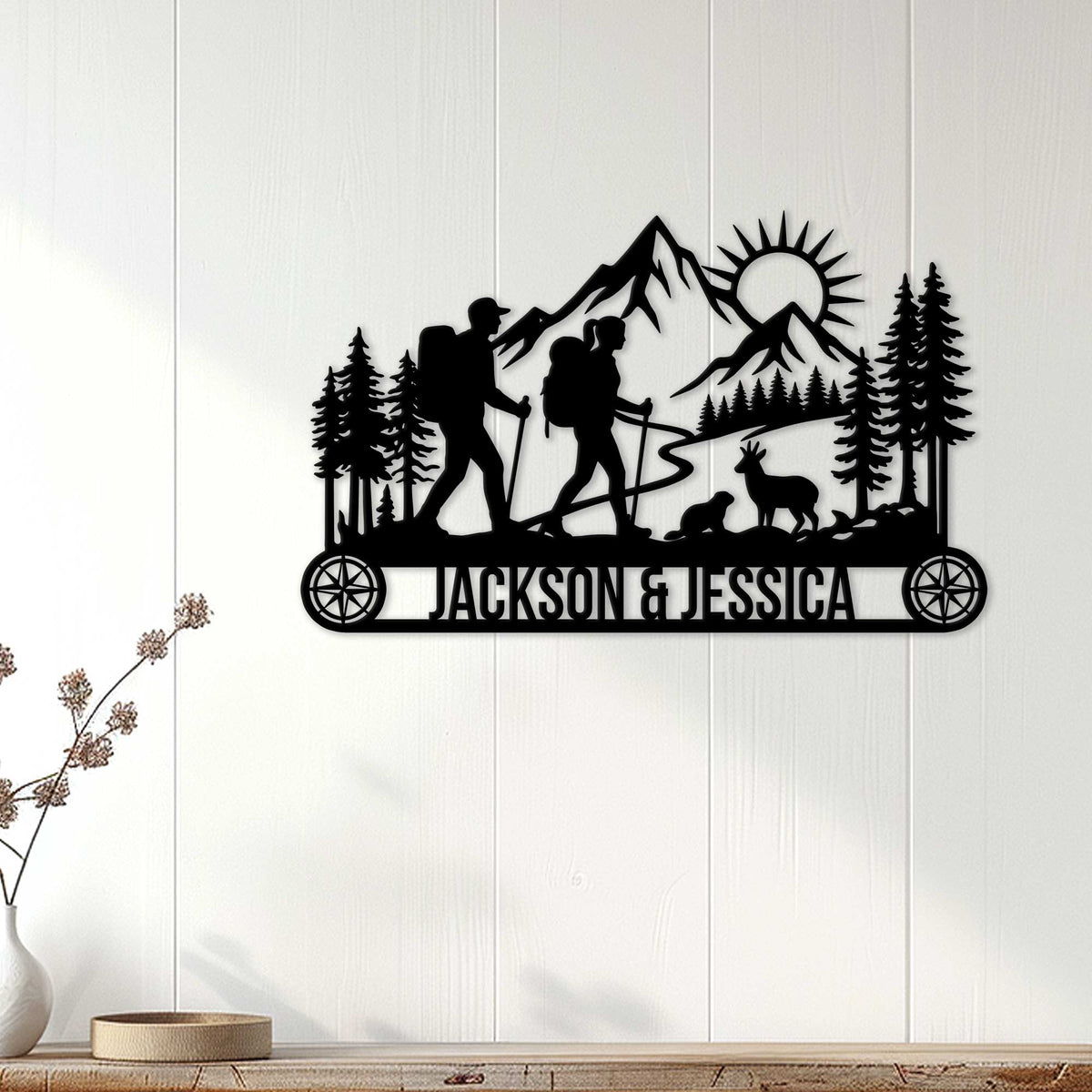 Black hiking couple silhouette sign displayed on a white wood-paneled wall