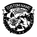 Custom tattoo artist metal sign featuring a tattoo machine, rose, ribbon banner, and bold black silhouette design