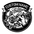 Black tattoo artist metal sign featuring a tattoo machine, rose, leafy floral accents, and bold banner design