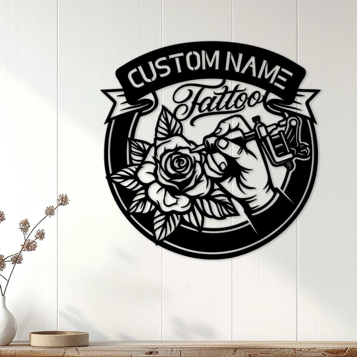 Tattoo artist metal wall sign displayed on a white paneled wall above a wood console