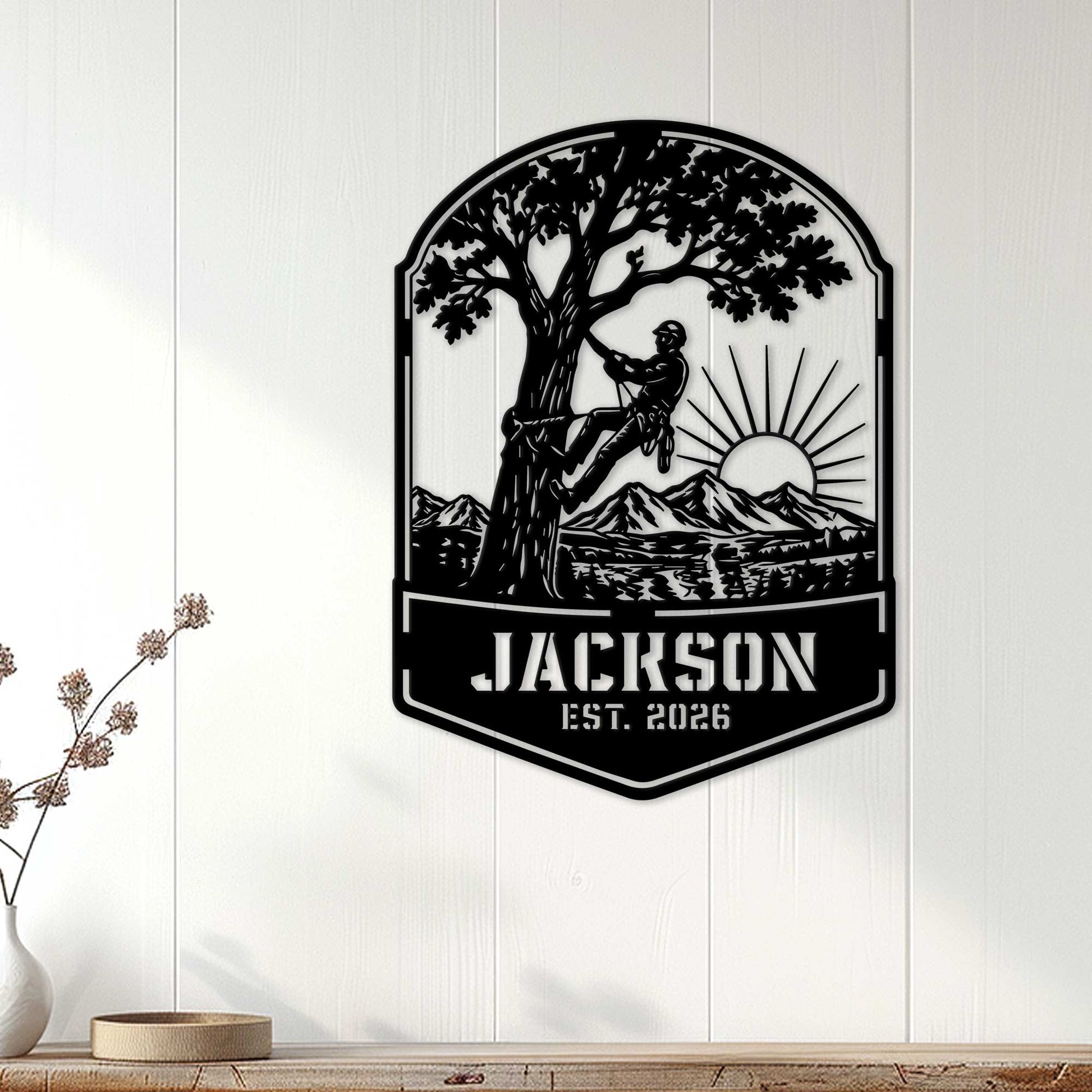 Arborist wall sign displayed on a white paneled wall, featuring a tree climber and mountain sunrise scene