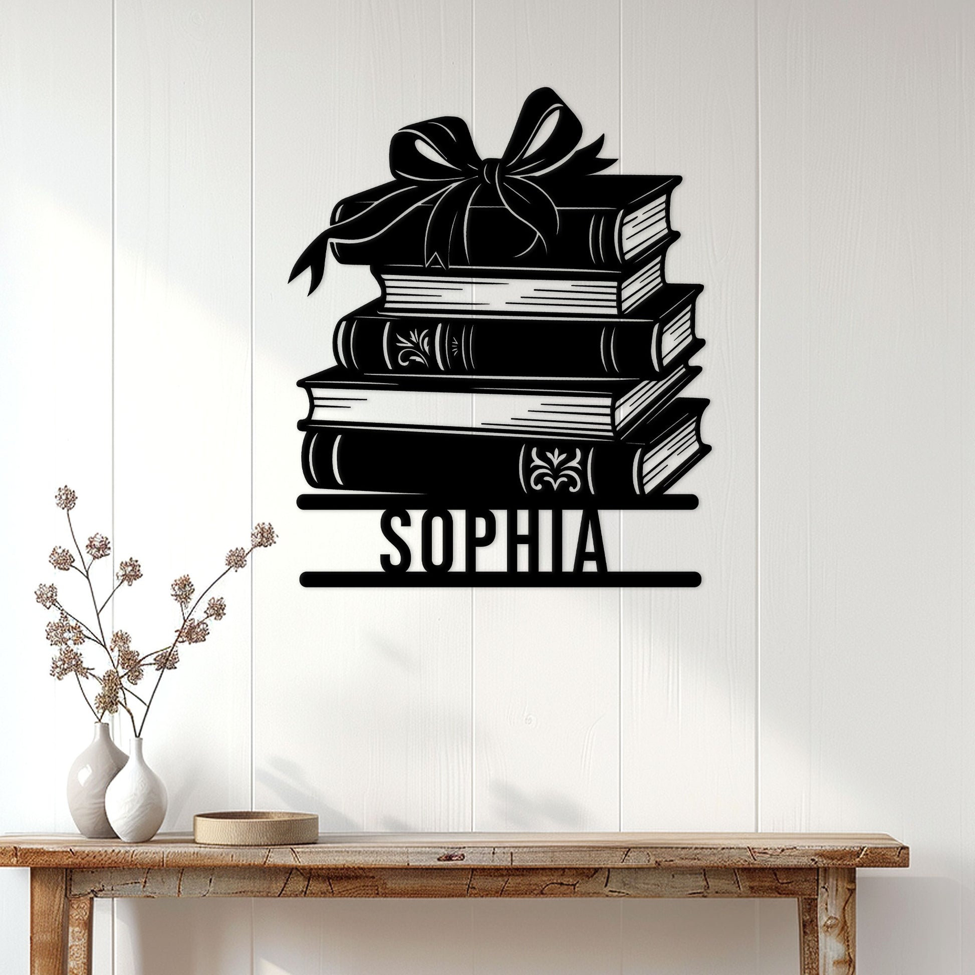 Book stack metal wall sign displayed on a light wood-paneled wall above a console table