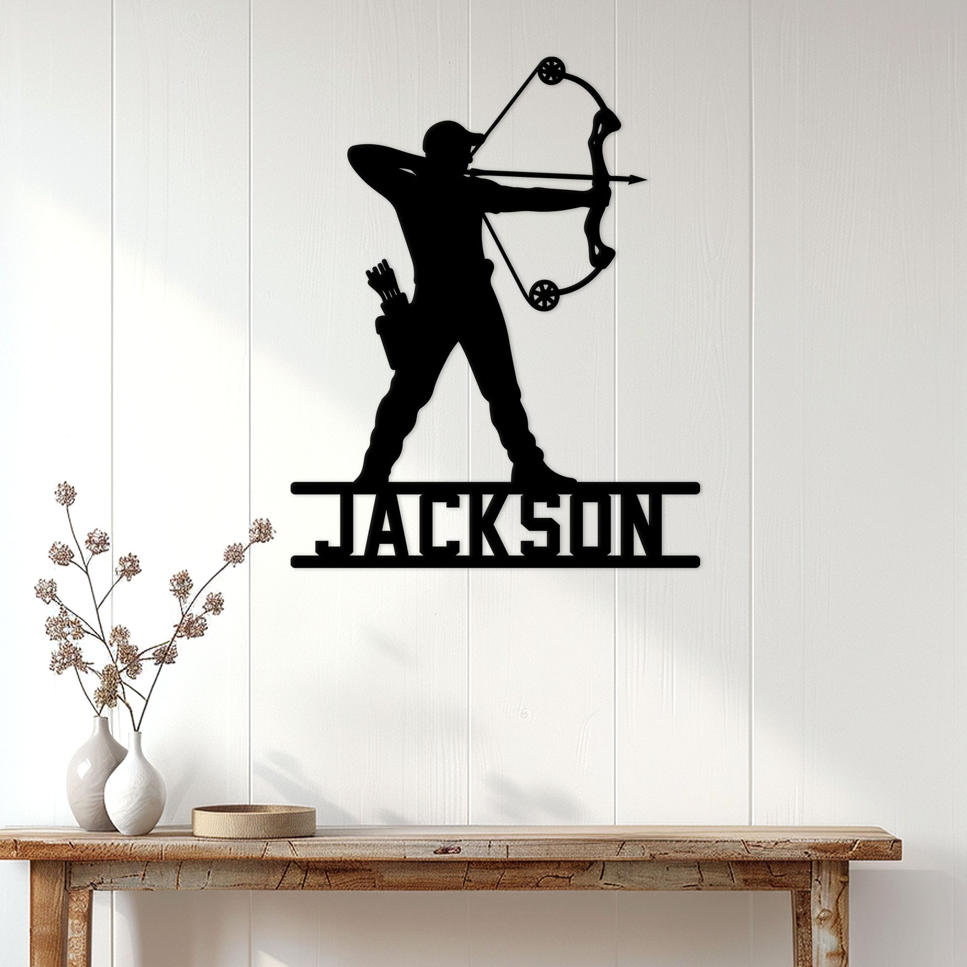 Custom archer metal wall sign displayed on a white paneled wall above a rustic console table
