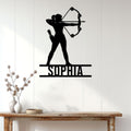 Black archer silhouette metal wall sign displayed on a bright paneled wall above a wood console