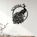 Black peacock wall sign displayed on a white paneled wall above a console for elegant home decor