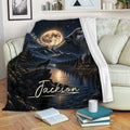 Wolf blanket draped over a sofa with moonlit lake, mountain, forest, and cabin artwork