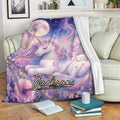 Custom unicorn blanket displayed on a sofa with pastel flowers, moonlit stars, and colorful fantasy artwork