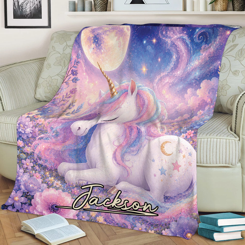 Unicorn throw blanket draped across a sofa, featuring a pastel rainbow mane, flowers, moon, and stars