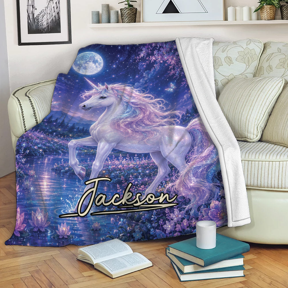 Unicorn throw blanket draped over a sofa with a moonlit fantasy scene, butterflies, and glowing flowers