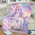 Colorful unicorn throw blanket displayed on a sofa with rainbow sky artwork