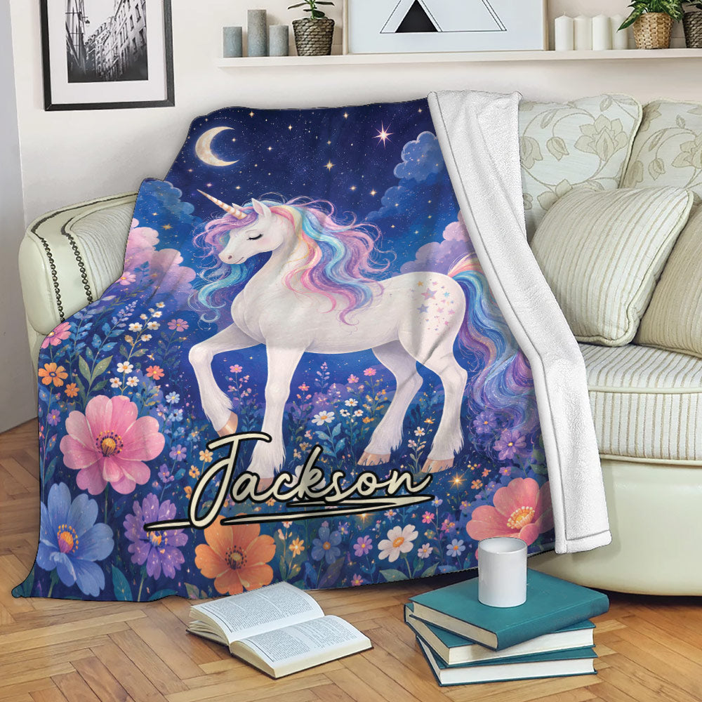 Magical unicorn throw blanket draped over a sofa with colorful flowers, stars, and a deep blue night sky