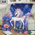 Close view of a colorful unicorn blanket featuring a rainbow mane, floral meadow, stars, and moonlit artwork