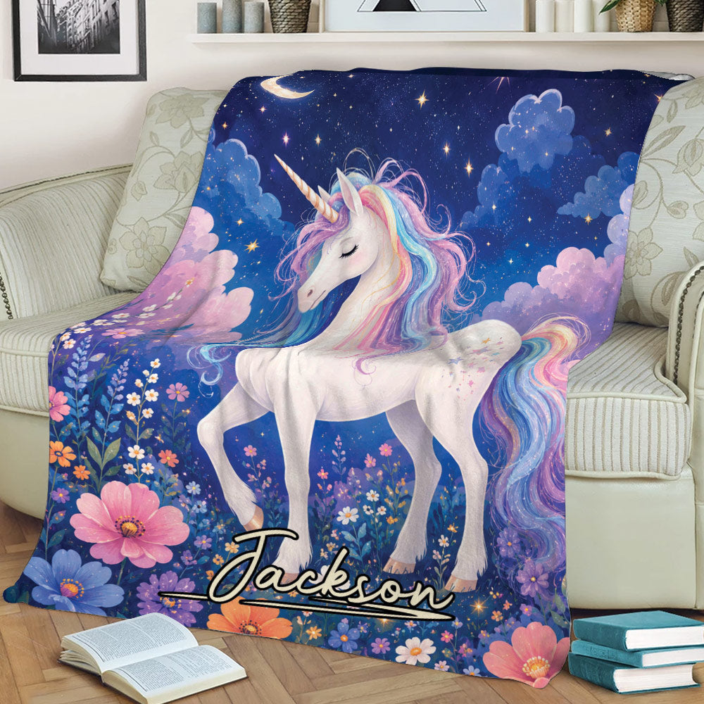 Close view of a colorful unicorn blanket featuring a rainbow mane, floral meadow, stars, and moonlit artwork