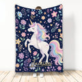 Unicorn throw blanket with pastel rainbow mane, floral details, stars, hearts, and a deep navy background