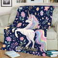 Unicorn blanket displayed on a couch with rainbow mane, floral accents, hearts, and celestial details