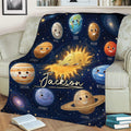 Space-themed throw blanket draped over a sofa with smiling planets and galaxy details
