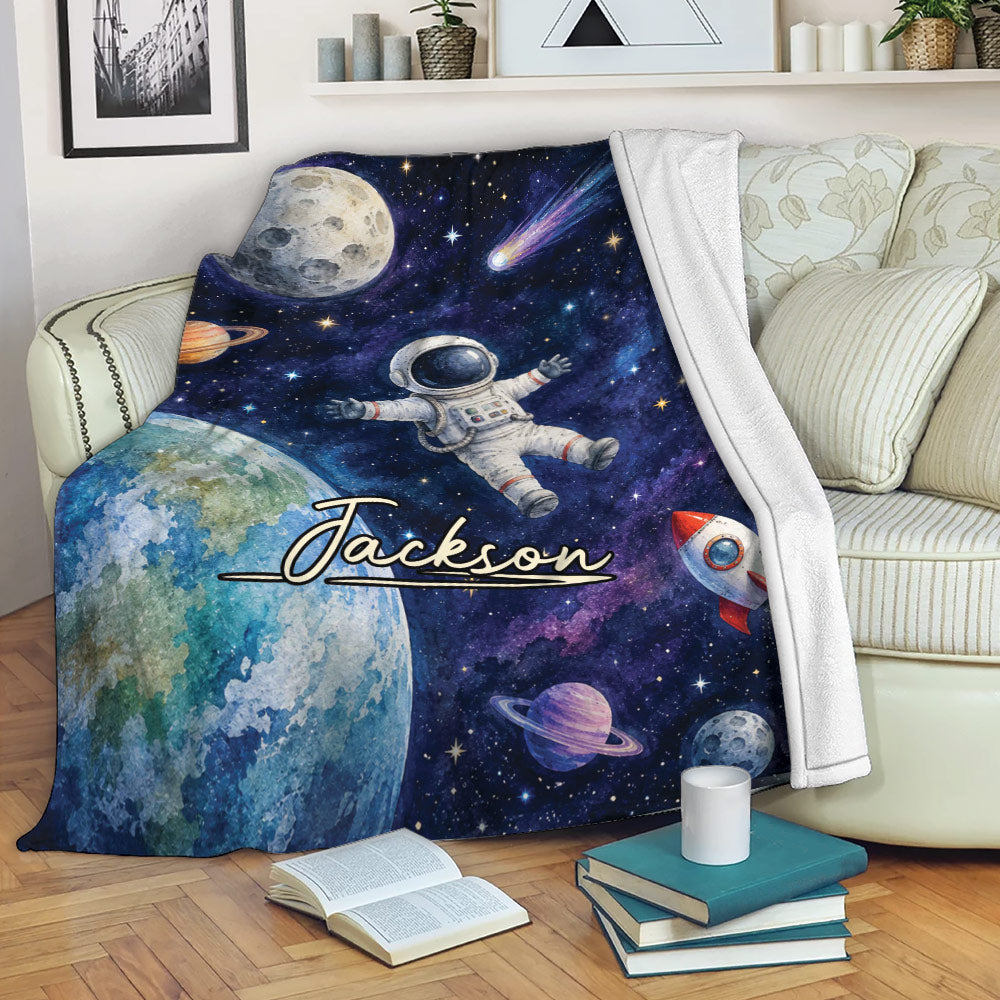 Astronaut blanket draped over a sofa with planets, stars, and space explorer artwork