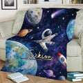 Space-themed astronaut throw blanket displayed on a sofa with planets and colorful galaxy art