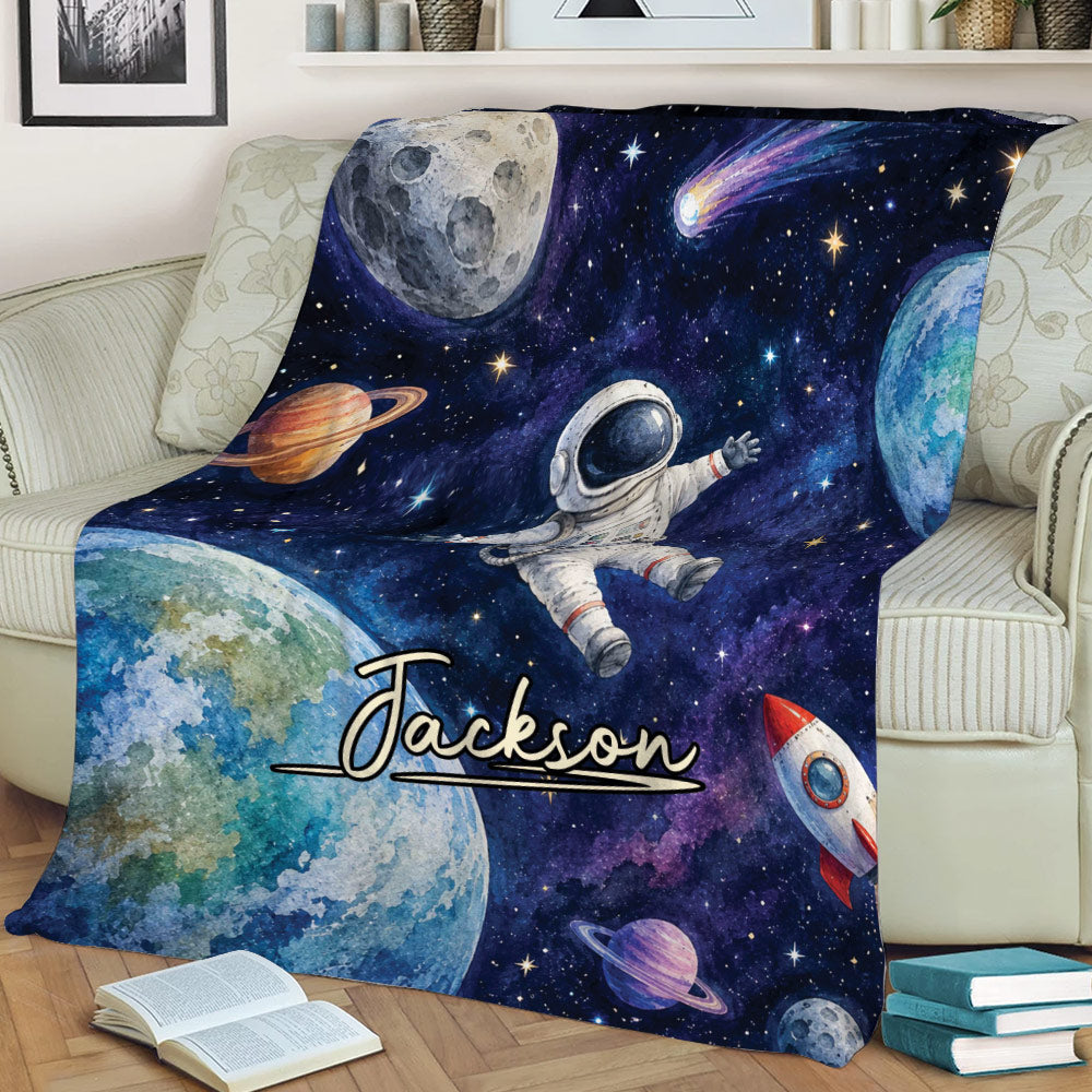 Space-themed astronaut throw blanket displayed on a sofa with planets and colorful galaxy art