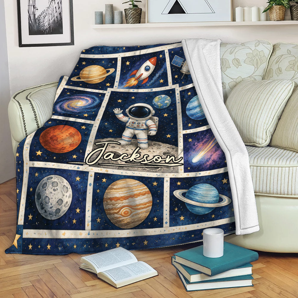 Astronaut space throw blanket draped over a sofa with planets, rocket, and galaxy artwork