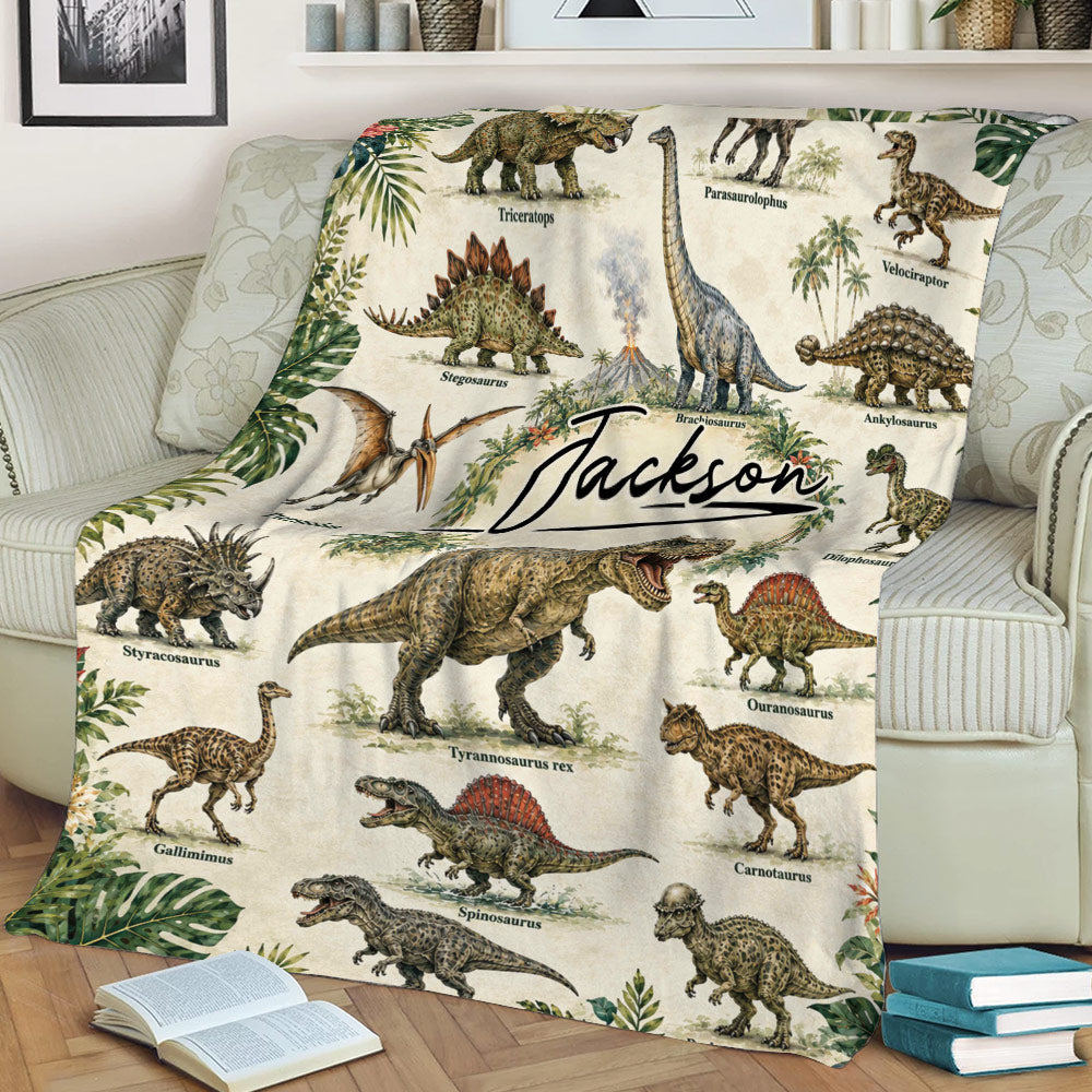Dinosaur throw blanket draped over a couch, featuring detailed dinosaur illustrations and tropical botanical accents