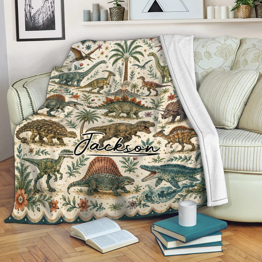 Dinosaur blanket draped over a sofa with vintage prehistoric artwork, tropical foliage, and a cozy reading setting