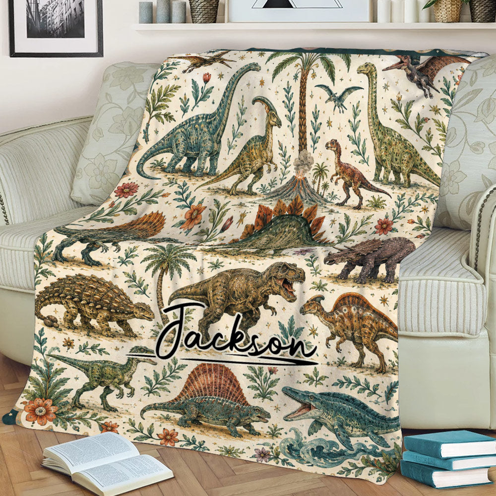 Close view of dinosaur throw blanket on a sofa featuring detailed prehistoric animals, palms, flowers, and ocean waves
